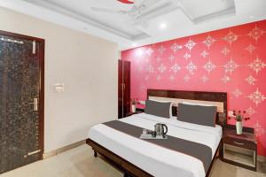 - une chambre avec un grand lit et un mur rouge dans l'établissement OYO Hotel Lotus, à New Delhi