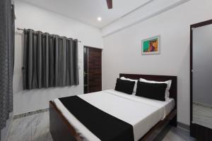 1 dormitorio con 1 cama grande con almohadas blancas y negras en Hotel Stay inn Chennai Airport en Chennai