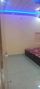1 dormitorio con 1 cama y luz azul en Shri KrishnMohini Home stay, en Mathura