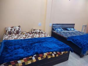 dos camas sentadas una al lado de la otra en un dormitorio en Shri KrishnMohini Home stay, en Mathura