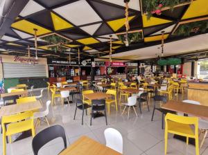 a restaurant with tables and chairs and yellow chairs at Apartamento entero Rebeca house in Santa Ana