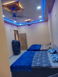 2 letti in una camera con luci blu di Shri KrishnMohini Home stay a Mathura