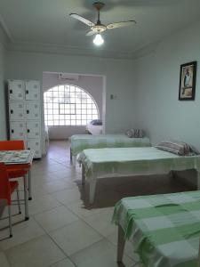 a hospital room with three beds and a ceiling fan at Pousada Solar do Lazer in Recife