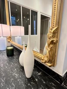 three white vases sitting on a counter in front of a mirror at L'élégant - Coeur de Toulouse in Toulouse