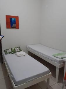 two beds in a room with a picture on the wall at Pousada Solar do Lazer in Recife