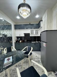 a kitchen with a glass table and a black refrigerator at BONUSHKA 5* in Samarkand