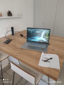 a laptop computer sitting on top of a wooden desk at studio au cap d'agde dans les pinèdes in Cap d'Agde