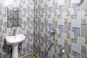 W łazience znajduje się umywalka i mozaikowa ściana. w obiekcie HOTEL CLINK A Butique Airport Hotel w Nowym Delhi