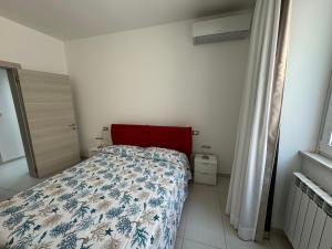 1 dormitorio con 1 cama con cabecero rojo en Casa al centro storico, en Pachino