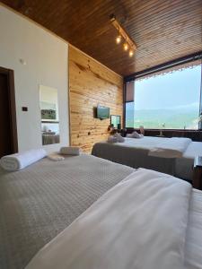 1 dormitorio con 2 camas y ventana grande en Karadeniz kus cenneti dağ manzaralı oda Ayvadere, en Araklı