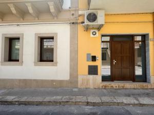 un edificio con una puerta y ventanas marrones en Casa al centro storico, en Pachino