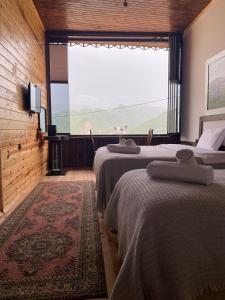 2 camas en una habitación con ventana grande en Karadeniz kus cenneti dağ manzaralı oda Ayvadere, en Araklı