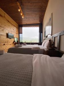 1 dormitorio con 3 camas y ventana grande en Karadeniz kus cenneti dağ manzaralı oda Ayvadere, en Araklı