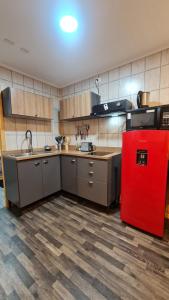 uma cozinha com um frigorífico vermelho num quarto em Radio Navarino em Puerto Williams