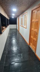 威廉斯港的住宿－Radio Navarino，一间空的走廊,房间铺有黑色地板