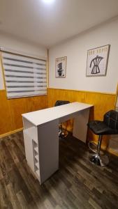 een kantoor met een wit bureau en 2 stoelen bij Radio Navarino in Puerto Williams