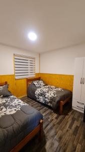 um quarto com 2 camas e uma janela em Radio Navarino em Puerto Williams