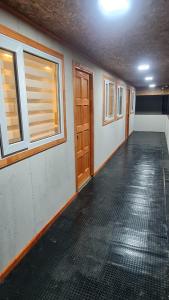 an empty room with wooden doors and windows at Radio Navarino in Puerto Williams