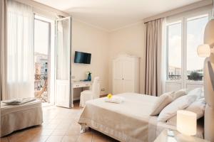 ein weißes Schlafzimmer mit einem Bett und einem Schreibtisch in der Unterkunft Hotel L'Arcangelo - Boutique Hotel in Taranto