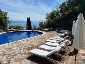 a group of lounge chairs next to a swimming pool at Maison Du Reve Scario in Scario
