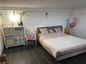 una camera con letto, cassettiera e sedia di LE COSY POUPY a Le Raincy