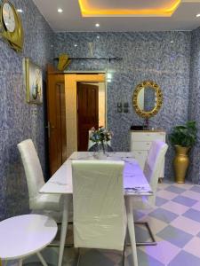 ein Esszimmer mit einem weißen Tisch und Stühlen in der Unterkunft Good Vibes in Cotonou