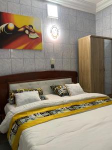 ein Schlafzimmer mit 2 Betten und einem Wandgemälde in der Unterkunft Good Vibes in Cotonou