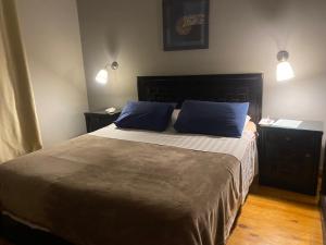 a bedroom with a large bed with two blue pillows at A cosy Apartment just for you to relax in 6th Of October +7 photos