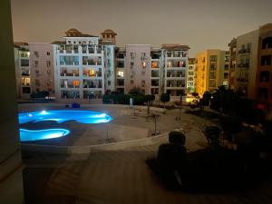 a large building with a swimming pool in front of it at A cosy Apartment just for you to relax in 6th Of October