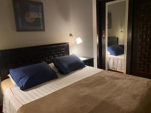 una camera da letto con un grande letto con cuscini blu di A cosy Apartment just for you to relax a Città del 6 ottobre