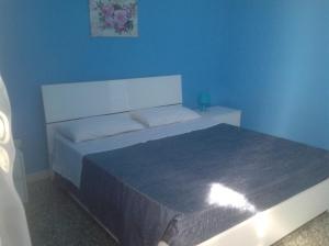 a bedroom with a bed with a blue wall at I Cieli Di Ostuni in Ostuni +32 photos