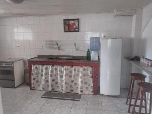 Il comprend une cuisine équipée d'une cuisinière et d'un réfrigérateur. dans l'établissement Apartamento espaçoso, à Cabo Frio