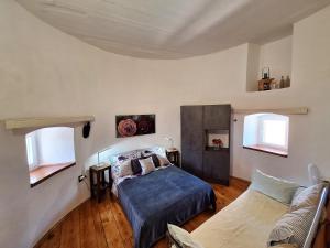 a bedroom with a bed and a couch and two windows at Old Mill in Rogoznica