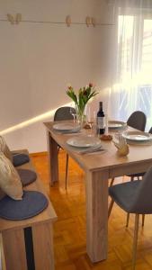 a table with a bottle of wine and flowers on it at Bright, Modern and Spacious - Apartment "Lola" Family & Workplace in Gießen