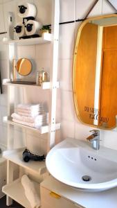 a bathroom with a sink and a mirror and towels at Bright, Modern and Spacious - Apartment "Lola" Family & Workplace in Gießen