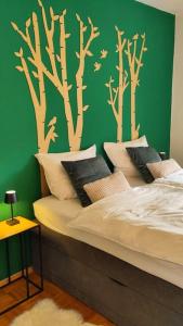 a bedroom with a bed with trees on the wall at Bright, Modern and Spacious - Apartment "Lola" Family & Workplace in Gießen