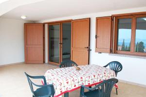 stół i krzesła w pokoju z oknem w obiekcie Appartamento con veranda e aria condizionata a Maladroxia C62 w mieście Maladroscia