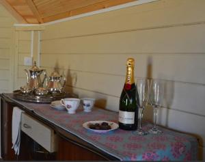 a bottle of wine sitting on a table with glasses at Apple blossom glamping in Kilkenny