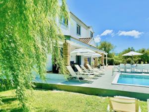 a villa with a swimming pool and a house at Villa Rubina Sidari with private pool by DadoVillas in Velonádes