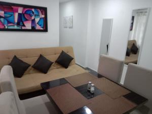ein Wohnzimmer mit einem Sofa und einem Tisch in der Unterkunft House Hotel Sweet Home 2 apartments in Medellín