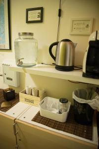 a kitchen counter with a coffee pot on a shelf at Europe Station Rooms in Parma