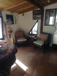 a bedroom with a bed and two chairs and windows at Houni House in Agriovótanon