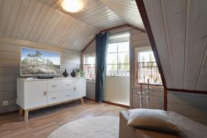 a bedroom with a white dresser and two windows at Vuokatin Aateli Apartments in Vuokatti