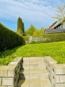 einen Steinweg, der zu einem Garten mit Hecke führt in der Unterkunft Scandinavian House Hotel-Lunden- Central 3 bedroom house in Horsens