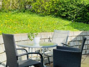 a table with two chairs and a vase on it at Scandinavian House Hotel-Lunden- Central 3 bedroom house in Horsens