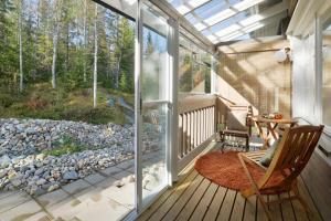 a screened in porch with a rocking chair and a table at Vuokatin Aateli Apartments in Vuokatti +6 photos