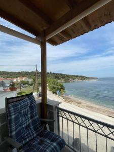 a chair on a balcony with a view of the beach at Vikis Dream Views in Skala Mistegnon