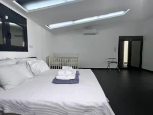 a bedroom with a white bed with towels on it at Two Bedroom Villa with Private Pool & Garden by Olivujoj in Anavyssos +38 photos