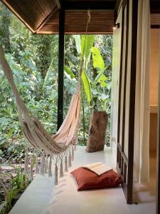 a hammock hanging from a room with a window at AIRE in Puerto Viejo