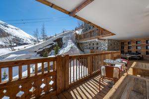 a balcony with a table and a snow covered mountain at Penthouse Best View - Les Chalets COVAREL in Val-d'Isère